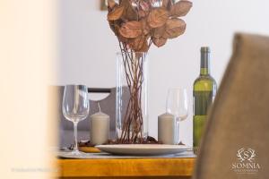 una mesa con un plato y un jarrón con flores y una botella de vino en Ferienwohnung Somnia - Altstadt Gmunden, en Gmunden