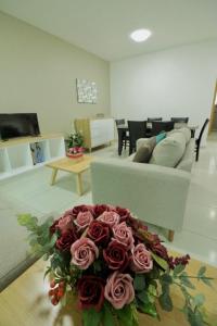 een woonkamer met een bank en een boeket rozen bij Shanarani Apartament in Uruapan del Progreso