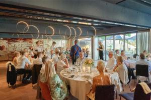 a group of people sitting at tables in a restaurant at Sonne Seehotel in Eich