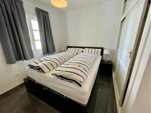uma cama com quatro almofadas num quarto em lux 2 kmr app Stella Blanca met zwembaden airco en zeezicht em Fuengirola