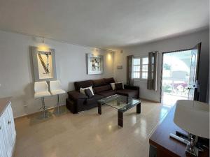 uma sala de estar com um sofá e uma mesa de vidro em lux 2 kmr app Stella Blanca met zwembaden airco en zeezicht em Fuengirola