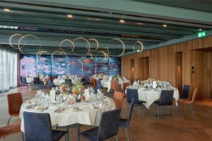 a conference room with tables and chairs and a chandelier at Sonne Seehotel in Eich