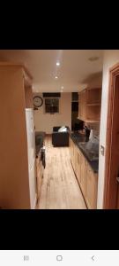 a kitchen with a refrigerator and a couch in a room at Spacious 2 bed appartment next to BAE with spa bath in Barrow in Furness