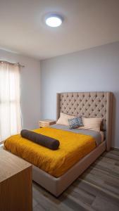 1 dormitorio con 1 cama grande con manta amarilla en Shanarani Apartament, en Uruapan del Progreso