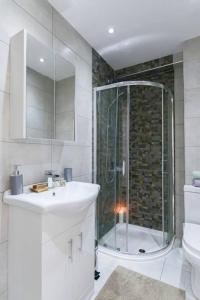 une salle de bain avec douche, lavabo et toilettes dans l'établissement City Sparrow Apartment 3, à Londres