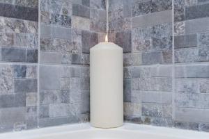 a white candle sitting on top of a bath tub at City Sparrow Apartment 3 in London