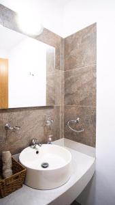 y baño con lavabo blanco y espejo. en Shanarani Apartament en Uruapan del Progreso