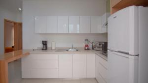 a white kitchen with a sink and a refrigerator at Shanarani Apartament in Uruapan del Progreso