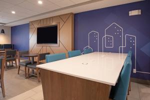 a conference room with a table and chairs and a tv at Holiday Inn Express Hotel & Suites Grand Junction, an IHG Hotel in Grand Junction