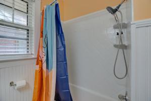 a shower curtain in a bathroom with a blow dryer at Spacious Bungalow with 6 Beds, Games, and Fire Pit - Close to Beale Street, BBQ, Graceland, & Liberty Bowl in Memphis +26 photos