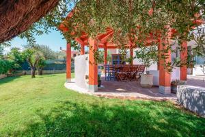 a pergola with a table and chairs in a yard at Villa Rosanna in Capoterra
