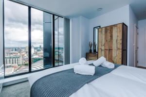 um quarto com uma cama grande e 2 toalhas brancas em Hilltop Serviced Apartments - Deansgate em Manchester