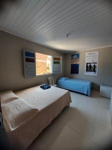1 Schlafzimmer mit 2 Betten und einem Fenster in der Unterkunft Suítes good trip itacare in Itacaré