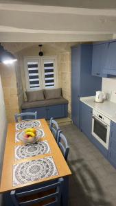 a kitchen with a table with a bowl of fruit on it at Valletta Home -Dar il-Kavallier Jacques de Quiqueran in Valletta