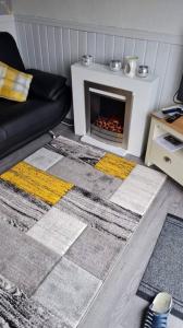 a living room with a fireplace and a couch at Beautiful 2-Bed Chalet in Aberystwyth in Aberystwyth