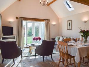 a living room with a dining room table and chairs at The Old Stables 1 in Winterslow