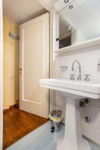 een witte badkamer met een wastafel en een spiegel bij Residence dei Frutti in pieno centro - Il Gelso in Padua