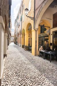een geplaveide straat in een steegje met tafels en gebouwen bij Residence dei Frutti in pieno centro - Il Gelso in Padua