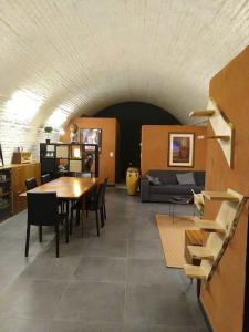 una camera con tavolo, sedie e divano di La Poudrière : lieu insolite, havre de paix a Vielsalm