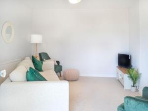 sala de estar con sillas verdes y sofá en Devon Hill, en Glenluce