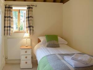 a small bedroom with a bed and a window at Talog Barn-uk31366 in Tregynon