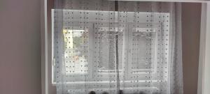 a window with white curtains in a room at Cazare Isa in Deva