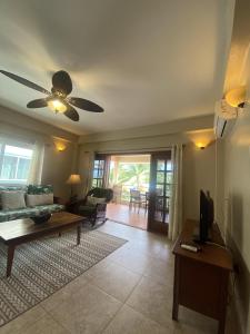 a living room with a couch and a ceiling fan at Placencia Pointe Townhomes #6 in Placencia Village