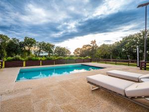 a swimming pool with two lounge chairs in a backyard at Casa do Gaiteiro 