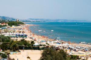 Una playa con mucha gente y el agua en Iris-Silvi Vacanza, en Silvi Marina