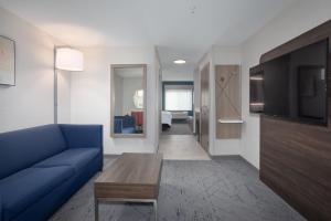 a living room with a blue couch and a tv at Holiday Inn Express Hotel & Suites Grand Junction by IHG in Grand Junction