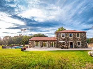 a stone building with a grassy field in front of it at Casa do Gaiteiro 