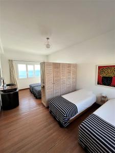 two beds in a room with wooden floors at logis la marine in Sidi Ifni