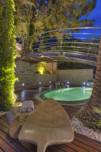 a swimming pool with a bench and a bridge over it at Hotel Forza Mare in Kotor