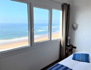 a bedroom with windows with a view of the beach at logis la marine in Sidi Ifni