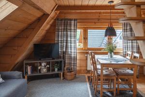 een eetkamer met een tafel en een tv in een hut bij Apartamenty u Giewonta in Zakopane