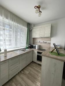 a kitchen with white cabinets and a counter top at Hanna's Apartament in Oradea