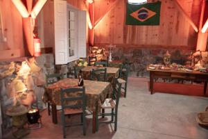 a restaurant with tables and a flag on the wall at Casarão Biazolli in Farroupilha
