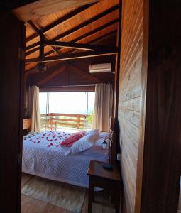 - une chambre avec un lit à baldaquin et une fenêtre dans l'établissement Chalé da Montanha com Ofurô, à Santo Amaro da Imperatriz