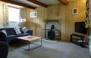 a living room with a couch and a fireplace at East Lane Barn in Aysgarth