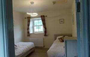 a bedroom with two beds and a window at East Lane Barn in Aysgarth