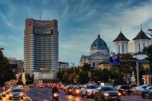 a busy city street filled with traffic with cars and buildings at Grand Hotel Bucharest in Bucharest