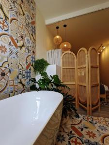 a room with a tub and a wall with tiles at 南門小宅 Southgate Dwell in Hengchun South Gate