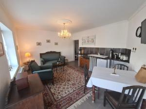 eine Küche und ein Wohnzimmer mit Tisch und Stühlen in der Unterkunft Überfahrt vor Sylt in Klanxbüll