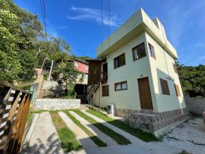 una casa blanca con una escalera delante en Fortaleza Logde, en Florianópolis