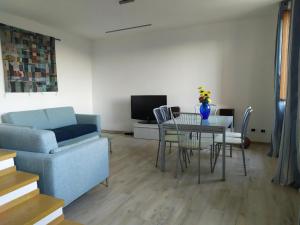 a living room with a table and a blue couch at Terrazza Arcius in Moncalvo