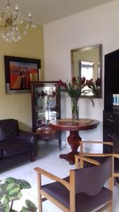 a living room with a table with a vase of flowers at Residencial Kontiki Miraflores in Lima