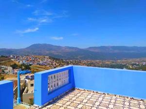 a blue balcony with a view of a city at Dar Achraf in Chefchaouen