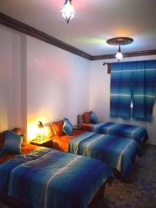1 Schlafzimmer mit 3 Betten in einem Zimmer in der Unterkunft Dar Achraf in Chefchaouen