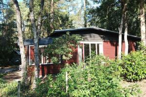 a small red house in the middle of trees at Bosbungalow de Eekhoorn in Nunspeet