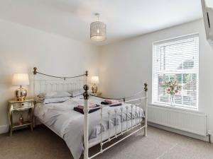 a bedroom with a white bed and a window at Twoo Hoots in Holt